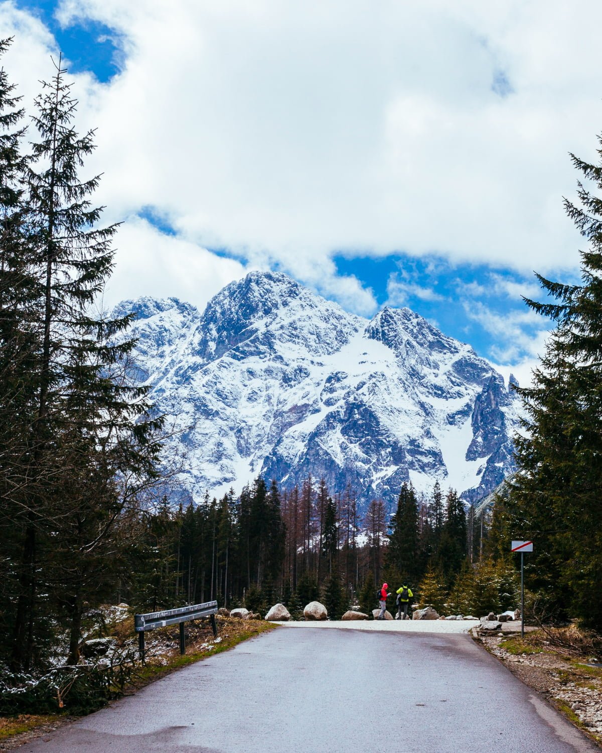 two-tourist-standing-road-near-snowy-mountain
